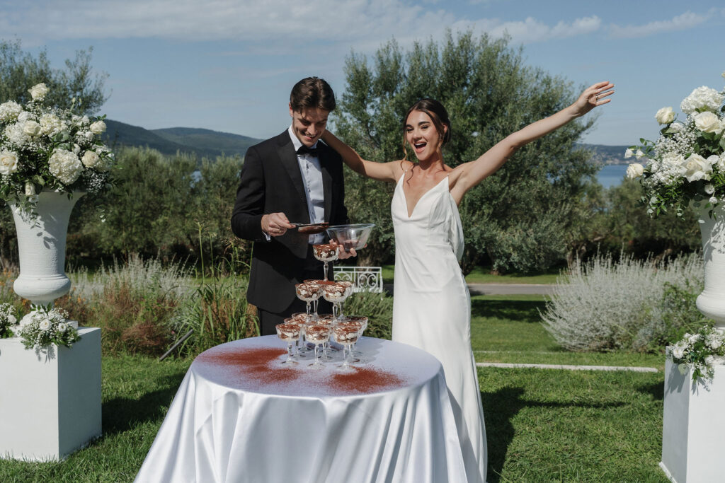 Brautpaar bestäubt den Tiramisu-Tower bei der Hochzeit in der Vigna Caio mit Kakao