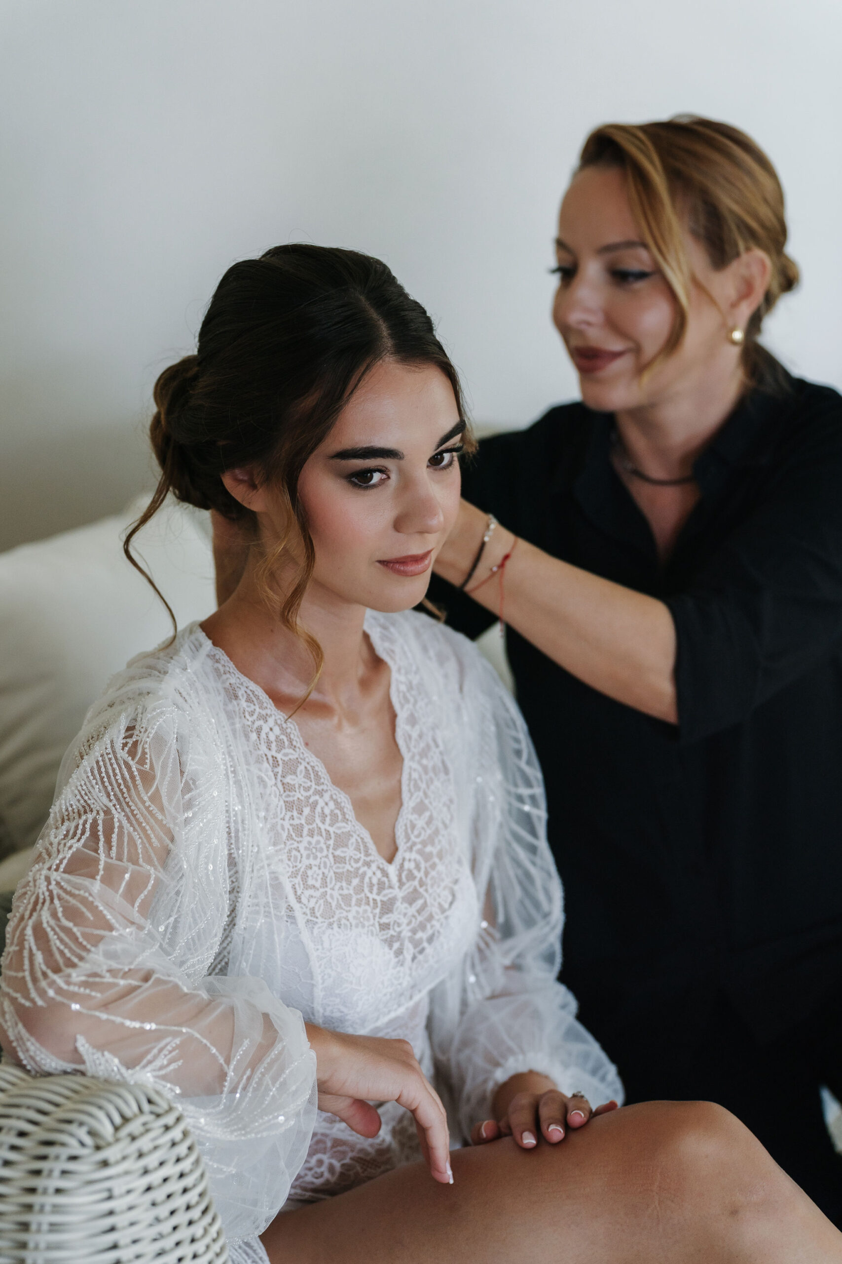 Braut und Stylistin beim Hair- und Make-up-Styling in der Vigna Caio