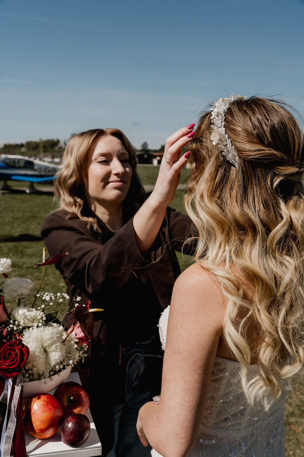 Stylistin richtet den Haarschmuck der Braut vor der Hochzeit